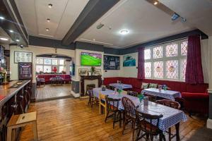 a restaurant with tables and chairs and a television at The Stag and Hen Pub in Coventry