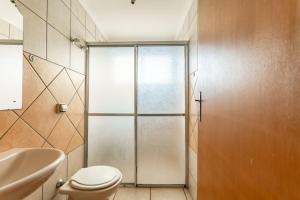 a bathroom with a toilet and a sink and a shower at Agrishow 26 - Apartamento Single e Duplo in Ribeirão Preto