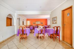 a dining room with purple tables and chairs at Agrishow 26 - Apartamento Single e Duplo in Ribeirão Preto