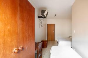 a small room with two beds and a room with a bed sqor at Agrishow 26 - Apartamento Single e Duplo in Ribeirão Preto