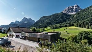 una casa en un valle con montañas en el fondo en Villa Rainer en Sesto