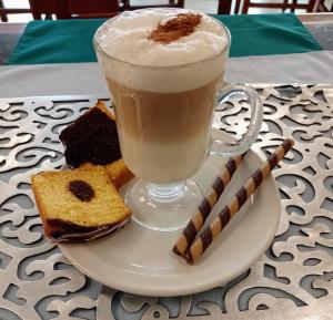 a plate with a cup of coffee and some cookies at Hotel Cuellar in Tula de Allende