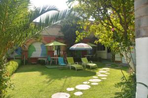 a yard with chairs and a table and umbrella at Hotel Cuellar in Tula de Allende