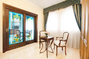 une pièce avec une table et deux chaises et une fenêtre dans l'établissement Grand Hotel President, à Olbia