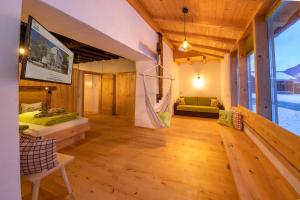 a room with a couch and a tv on the wall at Schloss Saalhof- Schlossflair, Wellnessauszeit, Bauernhofleben, Familienzeit im historischen Apartment zentral zwischen Zell am See und Saalbach-Hinterglemm in Maishofen