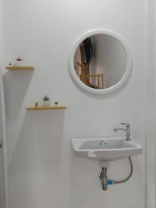 a bathroom with a sink and a mirror on the wall at Langkao Homestay Kohlibong หลังเขาโฮมสเตย์ เกาะลิบง in Ko Kwang