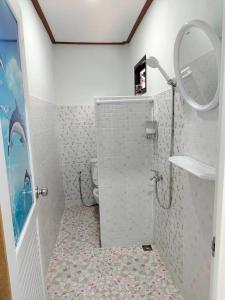 a bathroom with a shower with a toilet and a mirror at Langkao Homestay Kohlibong หลังเขาโฮมสเตย์ เกาะลิบง in Ko Kwang