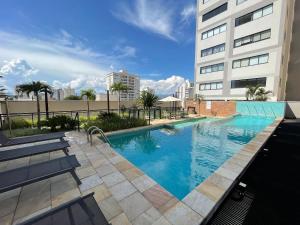 a large swimming pool in front of a building at Fully equipped apt: A/C, pool & gym in Downtown in Taubaté