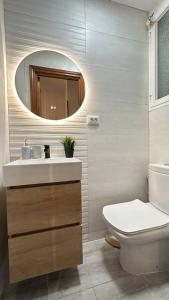 a bathroom with a sink and a toilet and a mirror at Habitaciones en Don Ramon in Madrid