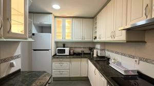 a kitchen with white cabinets and a white refrigerator at Habitaciones en Don Ramon in Madrid