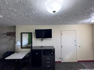 a room with a desk and a tv on a wall at Deerfield inn & Suits in Smyrna