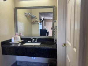 a bathroom with a sink and a large mirror at Deerfield inn & Suits in Smyrna