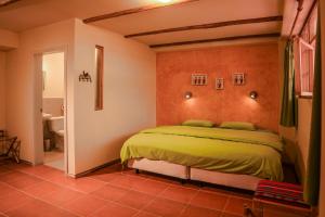 um quarto com uma cama grande num quarto em Inti Sisa Art Guesthouse em Guamote