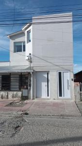 a white house with a driveway in front of it at Queen Apart in Río Gallegos
