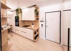 a kitchen with white cabinets and a white door at Wabi Sabi Nest in Timişoara