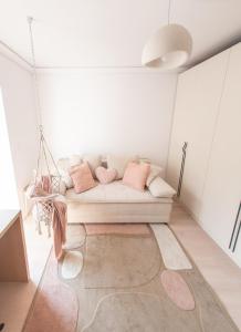 a living room with a white couch with pink pillows at Wabi Sabi Nest in Timişoara