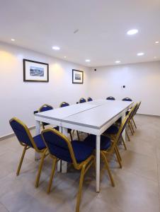 a conference room with a white table and chairs at Five Clover Hotel, Ilupeju in Lagos