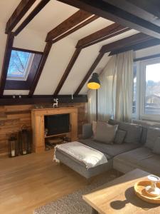 a living room with a couch and a tv at Ferienhaus Chiemgauer Auszeit- Chiemgaukarte inclusive in Siegsdorf