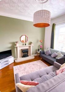 a living room with a couch and a fireplace at Light & Spacious Loch Lomond Apartment in Alexandria