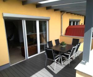 a patio with a table and chairs on a deck at Modern Doppelhaus in Baunatal