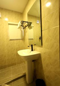 a bathroom with a sink and a mirror at Five Clover Hotel, Ilupeju in Lagos +20 photos
