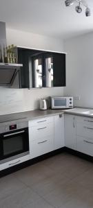 a kitchen with white cabinets and a microwave at Modern Doppelhaus in Baunatal +5 photos