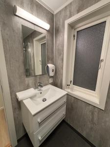 a bathroom with a sink and a mirror at Offersøy Feriesenter in Offersøy +53 photos