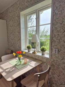 a dining room table with flowers in a vase at Villa Freja in Linköping