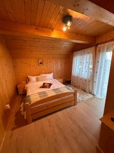 a bedroom with a bed in a wooden room at Cabana Apuseni N&D in Mărişel +55 photos