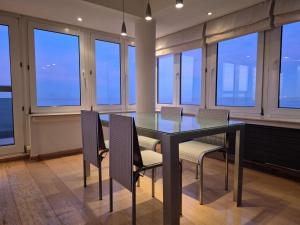 a dining room with a table and chairs and windows at Faro in Blankenberge