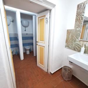a bathroom with a toilet and a sink and a door at Agorà Hostel in Pompei +35 photos