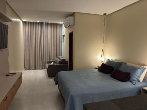 a bedroom with a bed and a living room at Flat em Alter do Chão in Alter do Chao