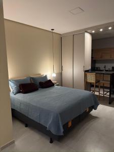 a bedroom with a large bed and a kitchen at Flat em Alter do Chão in Alter do Chao