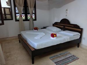 a bedroom with a large bed with flowers on it at Nelion Villas in Mambrui