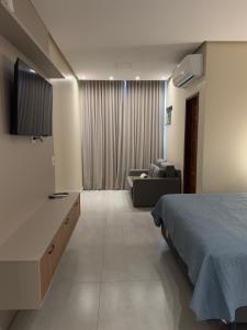 a hotel room with a bed and a couch at Flat em Alter do Chão in Alter do Chao