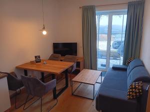 a living room with a blue couch and a table at Top 103 Lärchenhof in Mauterndorf