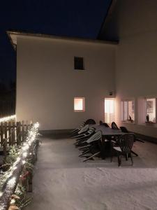 a dining room with a table and chairs at night at Gîte Sous le marronnier jusqu'à 10 personnes in Hadol