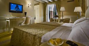 a hotel room with two beds and a television at Ca' Murà Natura e Resort in Maserà di Padova +32 photos