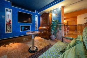 a living room with blue walls and a table at Hotel Luis in Fiera di Primiero