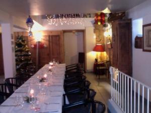 una lunga sala da pranzo con un lungo tavolo e sedie di L'AUBERGE CHEZ LEON a Le Chambon-sur-Lignon