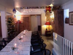 a long dining room with a long table and chairs at L'AUBERGE CHEZ LEON in Le Chambon-sur-Lignon