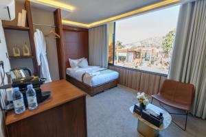 a hotel room with a bed and a large window at فندق شادن الفخامة in Taif