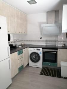a kitchen with a washing machine and a dishwasher at Como en tu casa in Zaragoza