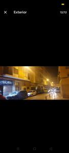 two photographs of a city street at night with cars parked at Como en tu casa in Zaragoza