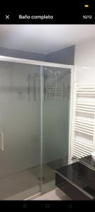 a glass cabinet with a glass table in a room at Como en tu casa in Zaragoza +1 photo