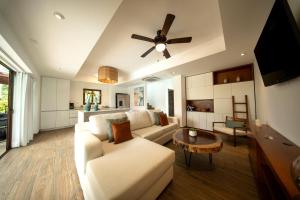 a living room with a couch and a ceiling fan at Designer Villa with Direct Pool Access in Monterrico