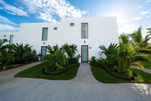 a white house with palm trees in front of it at Designer Villa with Direct Pool Access in Monterrico