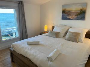 a bedroom with a large white bed with a large window at Exceptional Waterfront Villa in Hyères