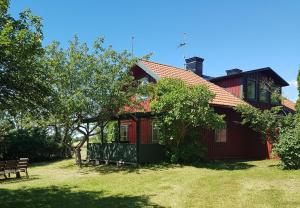a red house with a bench in front of it at Villa Freja in Linköping