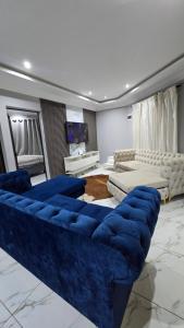 a living room with a blue couch in a room at HUZULA Royal Residence in Empangeni